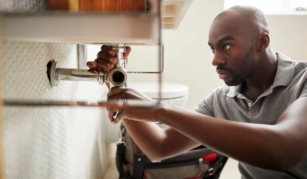 a male plumber fixing a pipe connection a male plumber fixing a pipe connection